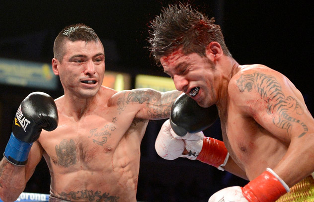 Lucas Matthysse (L) connects hard with John Molina's face during their fight in April 2014. Photo by Naoki Fukdua.
