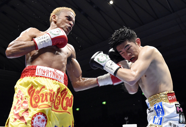 IBF flyweight titleholder Amnat Ruenroeng (left), of Thailand, lands a left hook to Japan's Kazuto Ioka during their match in Osaka, Japan, on May 7. Amnat defeated Ioka by split decision. Photo by JIJI PRESS/AFP/Getty Images