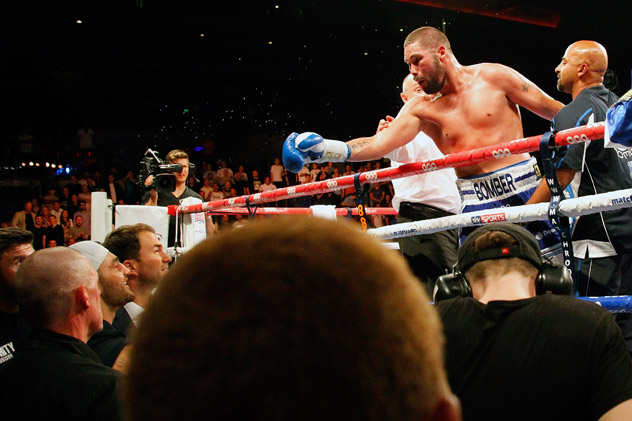 July 12, 2014: Cruiserweight Tony Bellew calls out rival Nathan Cleverly (wearing cap) from the ring after beating Julio Cesar Dos Santos in Liverpool. Photo by Paul Thomas/Getty Images.
