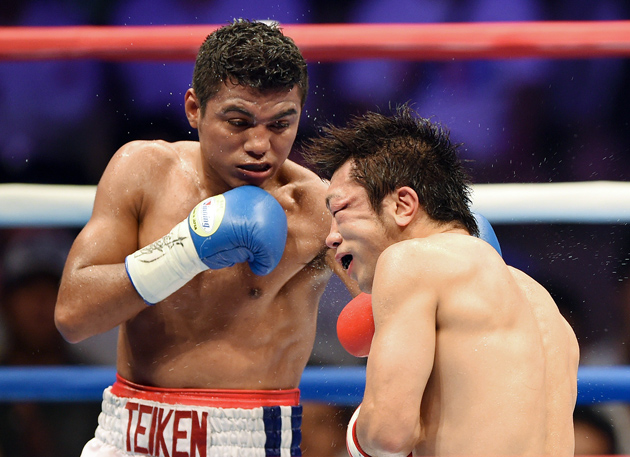 Roman Gonzalez (left) lands a left hook to RING magazine and WBC flyweight champion Akira Yaegashi en route to scoring a ninth-round stoppage in Tokyo on Sept. 5. Photo by Toshifumi Kitamura/AFP/Getty Images