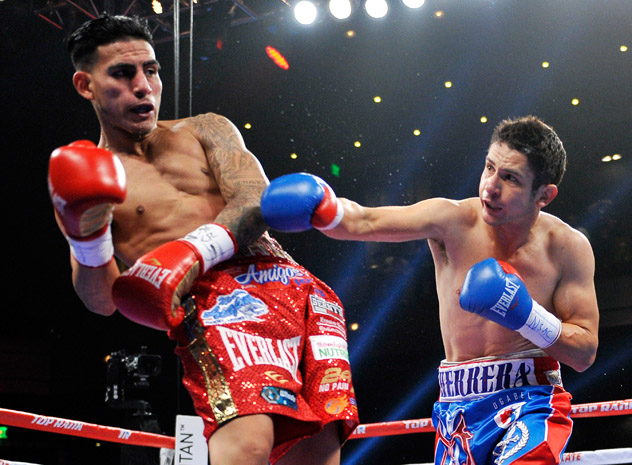 Mauricio Herrera takes it to Jose Benavidez Jr. during their 12-round junior welterweight bout in December 2014. Benavidez won a controversial decision. Photo by David Becker/Getty Images