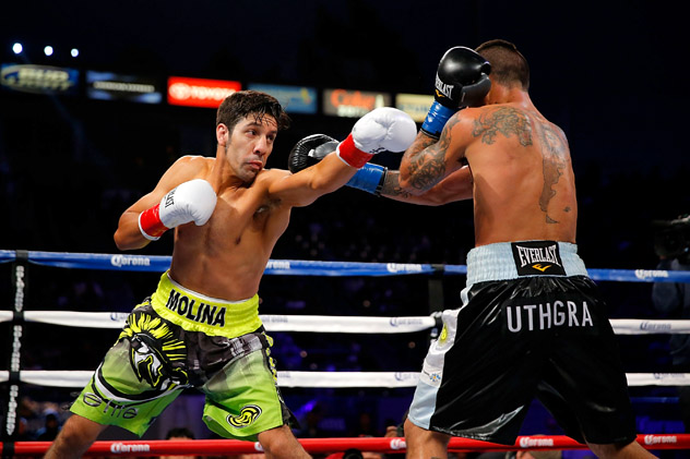 John Molina (L) lunges at Lucas Matthysse on April 26, 2014, during what would be name THE RING Magazine's Fight of the Year. Both fighters went down twice before Molina was stopped in the 10th round. Photo by Joe Scarnici/Getty Images.