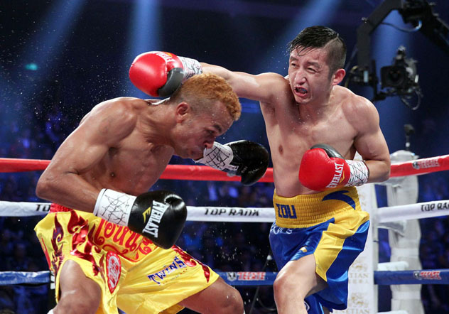 Zou Shiming (R) fighting flyweight titleholder Amnat Ruenroeng on March 7, 2015. Photo by Chris Farina - Top Rank.