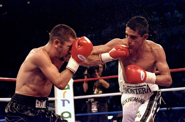 Wayne McCullough (L) battles then-WBC junior featherweight titleholder Erik Morales in October 1999. Morales successfully defended his belt by a unanimous decision. Photo by John Gichigi/Getty Images.