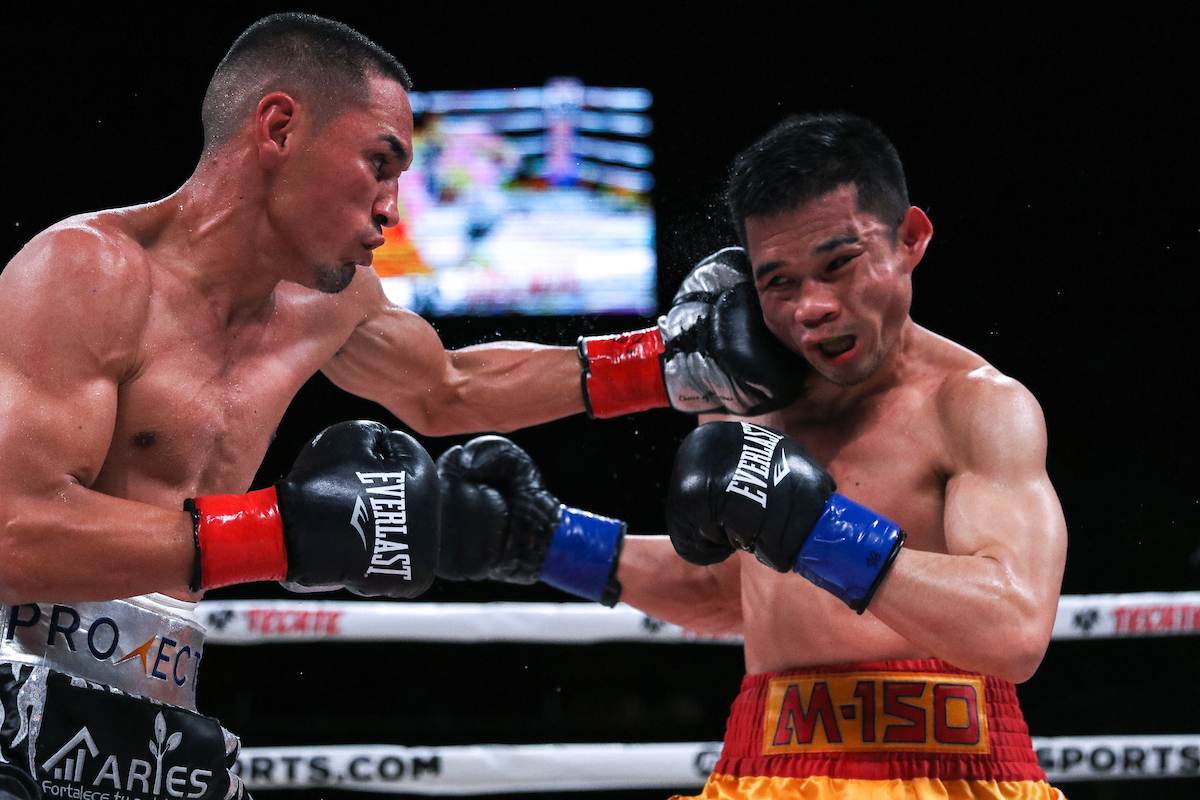 Juan Francisco Estrada (left) seized The Ring Magazine/WBC 115-pound championships from Srisaket Sor Rungvisai at The Forum in Inglewood, California, with punches like this left hook. Photo by Melina Pizano/Matchroom Boxing USA